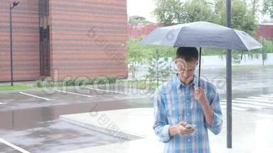 使用智能手机，雨中撑伞